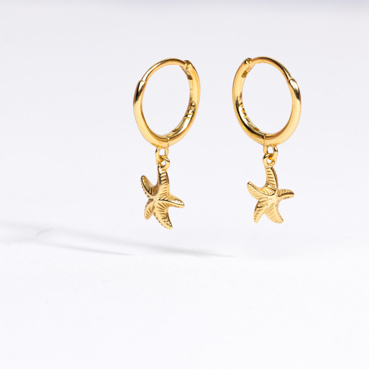 Splendid Starfish Earrings in front of a white background.